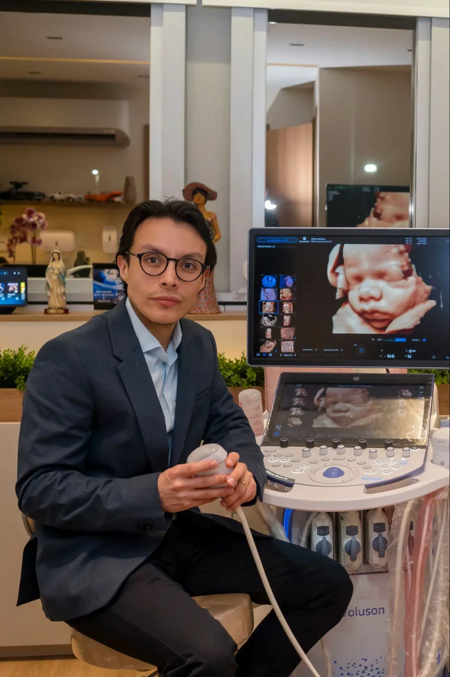 Dr. Héctor Burbano, obstetra e especialista em medicina fetal, com o transdutor de ultrassom ao lado do aparelho GE Voluson, no consultório na Barra da Tijuca